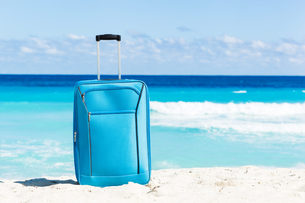 suitcase on a beach Thomas Smith Insurance Agency