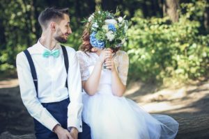 adult couple newlyweds on their wedding day holding bouquet and having fun