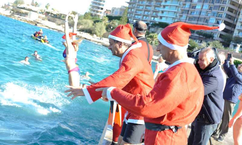 people dressed as santa clause about to jump in the sea for the thomas smith charity swim, christmas swim
