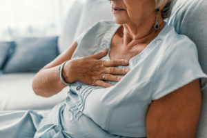 woman holding her chest because of heart disease