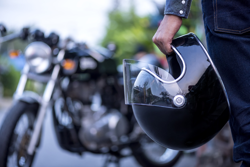 biker holding helmet in hand before riding a motorcycle