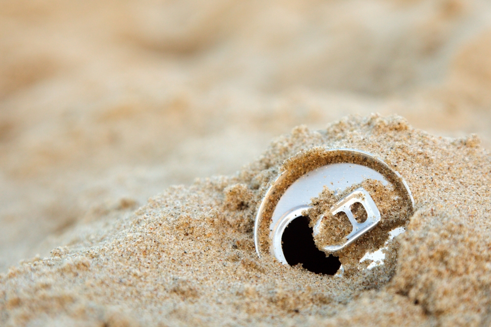 empty tin can throw at the beach in the sand