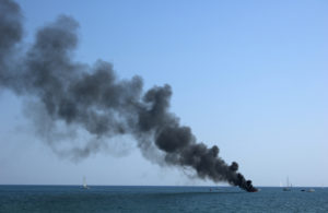 fumes coming out of a boat at sea showing fire damage