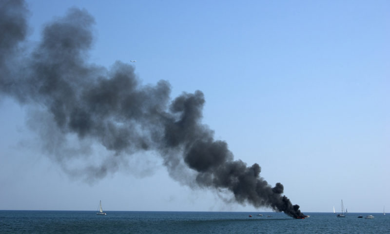 fumes coming out of a boat at sea showing fire damage