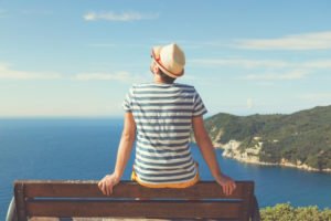 man sitting on bench looking at view during vacation