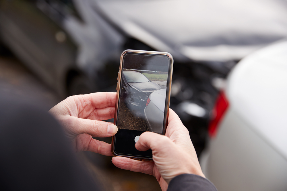 person taking photo of car accident